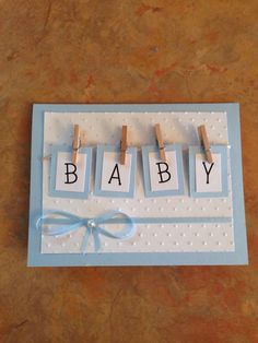 a baby card with clothes pins hanging from the clothes line