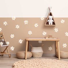 a child's room with white flowers on the wall and a teddy bear sitting in a chair