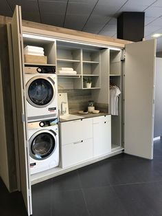 a washer and dryer sitting in a room next to an open cabinet door