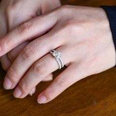 a woman's hand with a ring on it and two diamonds in the middle