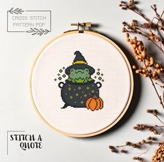 a cross - stitch pattern of a witch with a pumpkin