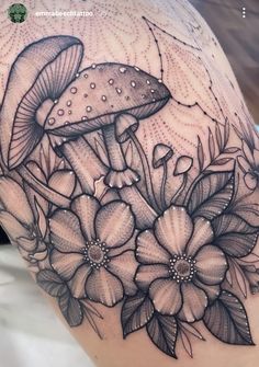 a woman's thigh with flowers and mushrooms on it