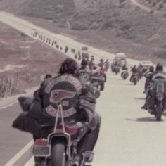 a group of motorcyclists riding down the road on their own side,