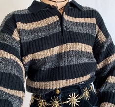 a close up of a person wearing a sweater and skirt with sun charms on it