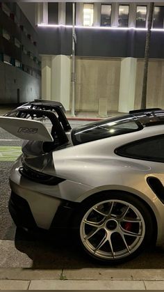 a silver sports car parked in front of a building