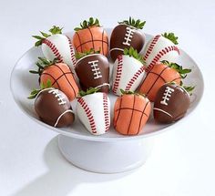 chocolate covered strawberries with football decorations on them in a white bowl, ready to be eaten