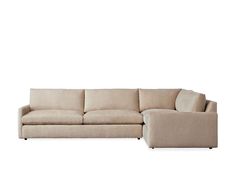 a beige sectional couch sitting on top of a white floor