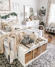 a bedroom with white walls and black and white rugs on the floor is decorated with fall decorations