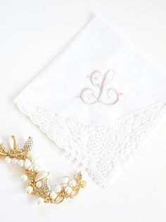 the monogrammed handkerchief is adorned with pearls and gold - tone brooches