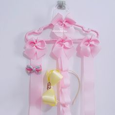 pink and yellow bows are hanging on a hanger