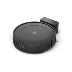 a black robot vacuum on a white surface