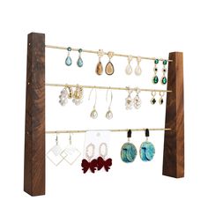 a wooden rack with earrings hanging from it