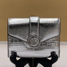 Michael Kors Carmen Medium Faux Leather Wallet Silver Crocodile Print Pattern Nwt Authentic Reimagined In A Shrunken Silhouette From Faux Leather, This Wallet Version Of Our Beloved Carmen Bag Will Stylishly Keep Your Essentials Within Arm’s Reach. Featuring A Foldover Closure And Our Iconic Charm, It’s As Polished As It Is Practical. Wallet Faux Leather 88.92% Coated Canvas/11.08% Polyester Gold-Tone Hardware 4.75"W X 3.75"H X 1.25"D Exterior Details: Back Slip Pocket Interior Details: 2 Back Z Exterior Details, Crocodile Print, Crocodile Pattern, Print Pattern, Interior Details, Leather Wallet, Print Patterns, Gold Tones, Michael Kors