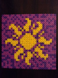 a purple and yellow piece of art made out of perforated material with dots