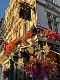 the outside of a building with flowers hanging from it's balconies