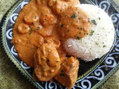 a black and white plate topped with rice and meat