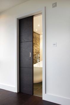 an open door leading to a bathroom with a tub