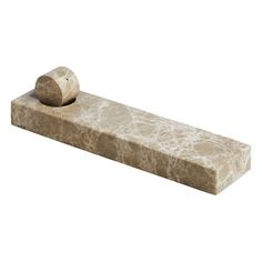 a stone object with a rock on it's end and a piece of wood sticking out of the top