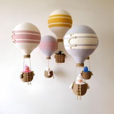 three hot air balloons are hanging from the wall and one has a baby in it