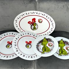 four plates with designs on them sitting next to each other in front of a gray wall