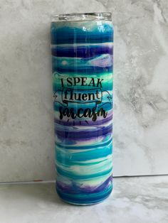 a blue and purple tumbler with the words i speak twenty sarcastics on it