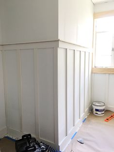 a room that is being painted white and has some tools on the floor next to it