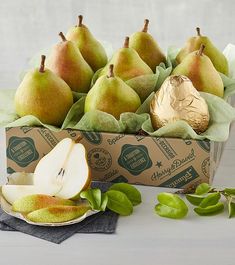 pears and other fruit in a box on a table