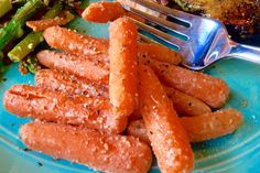 a blue plate topped with carrots and asparagus next to broccoli