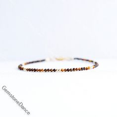 Tiger's Eye Bracelet  Finished with a lobster clasp. *BRACELET LENGHT- 6.0, 6.5, 7.0, 7.5, 8.0 Inches* * MATERIALS & DIMENSIONS * * Tiger Eye Beads: about 2 mm - Grade AAA * Gold Filled or Sterling Silver Beads: about 2.0 mm * Gold Filled or Sterling Silver Findings * Premium Strong Flexible Beading Wire *Arrives in a gift box* Choose Your Bracelet Length Use a tape measure. Wrap the tape measure around the wrist on which you plan to wear your bracelet. Make a note of the number at the point where the tape meets the 0. To ensure the bracelet fits comfortably, add 1/2 or 1 inch depending on how tight or loose you like to wear your bracelet. I gladly accept returns Contact me within: 3 days of delivery Returns & exchanges accepted within 30 days Buyers are responsible for return shipping cos Adjustable Brown Bracelets With Lobster Clasp, Adjustable Brown Bracelet With Lobster Clasp, Minimalist Brown Beaded Bracelets For Gifts, Elegant Brown Bracelet With Lobster Clasp, Brown Bracelet With Lobster Clasp As Gift, Tiger Eye Bracelet, Bracelet Dainty, Clasp Bracelet, Tiger Eye Beads