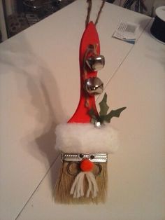 a santa hat hanging on the side of a white counter top with bells and holly