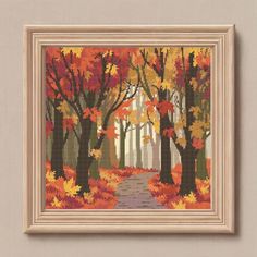 an autumn scene with trees and leaves in the foreground, framed on a wall