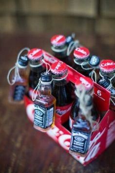 a bunch of soda bottles sitting in a red box on top of a wooden table