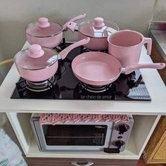 pink pots and pans are sitting on top of the stove