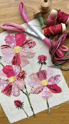 a table with some thread and flowers on it