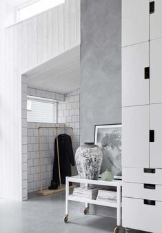 a vase sitting on top of a table next to a white cabinet in a room