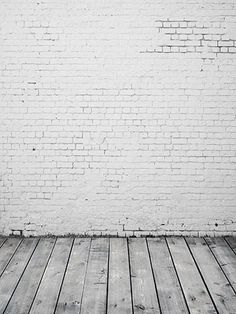 an empty white brick wall and wooden floor