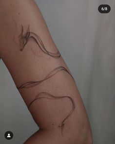 a woman's arm with a tattoo on it that is shaped like a snake