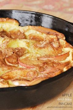 an apple dutch baby pancake in a cast iron skillet on a wooden table