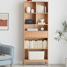 a living room with a blue chair and book shelf