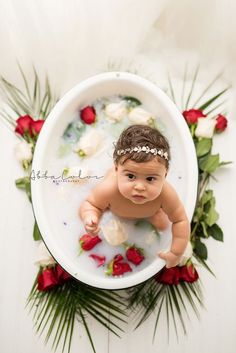 an overhead view of a baby in a bath with flowers