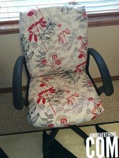 an office chair with flowers on it sitting in front of a window, next to a rug