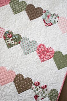 a close up of a quilt with hearts on it