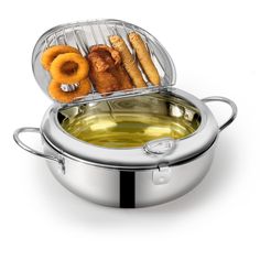 a stainless steel pan filled with food on top of a white table next to a frying pan