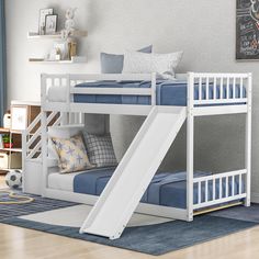 a white bunk bed with a slide on the bottom and mattresses underneath it in a child's bedroom