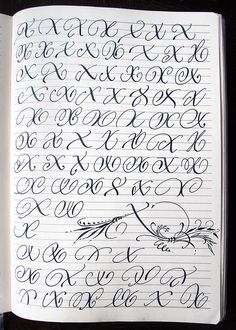 an open notebook with cursive writing on the pages and some black ink in it