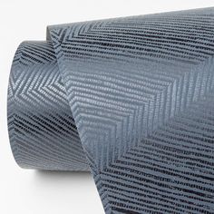 a close up of a blue tie on a white surface with diagonal lines in the background