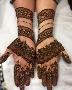 two hands with henna designs on them