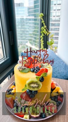 a birthday cake decorated with fruit and the words happy birthday written on top of it