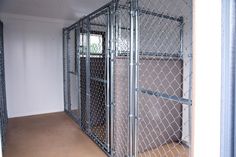 the inside of a dog kennel with doors open