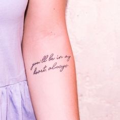 a woman with a tattoo on her arm that says, you'll be in my heart always